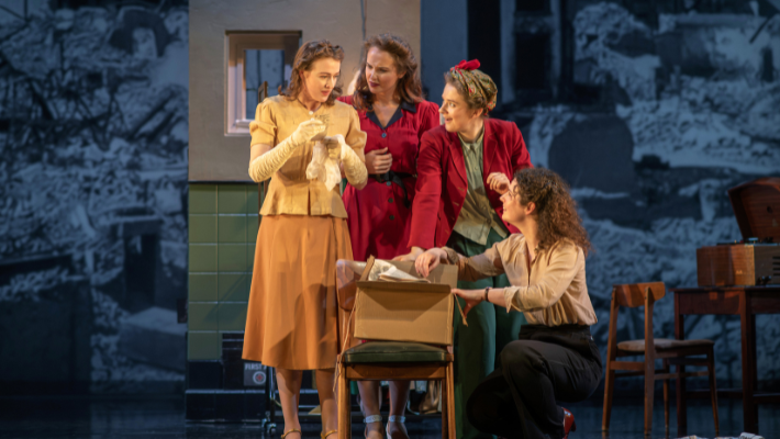 Four women are gathered together looking at a parcel that has been sent to a boarding house post World War Two. The women are acting in The Girls of Slender Means at the Lyceum.