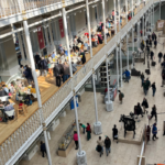 Looking down into the main hall at the National Gallery. It is flooded with light and busy with people.
