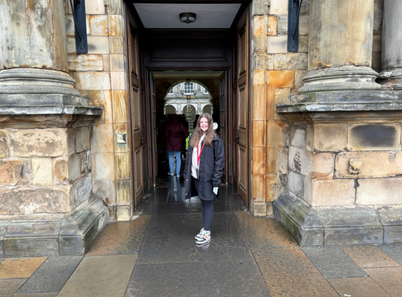 A girl stands in a doorway.